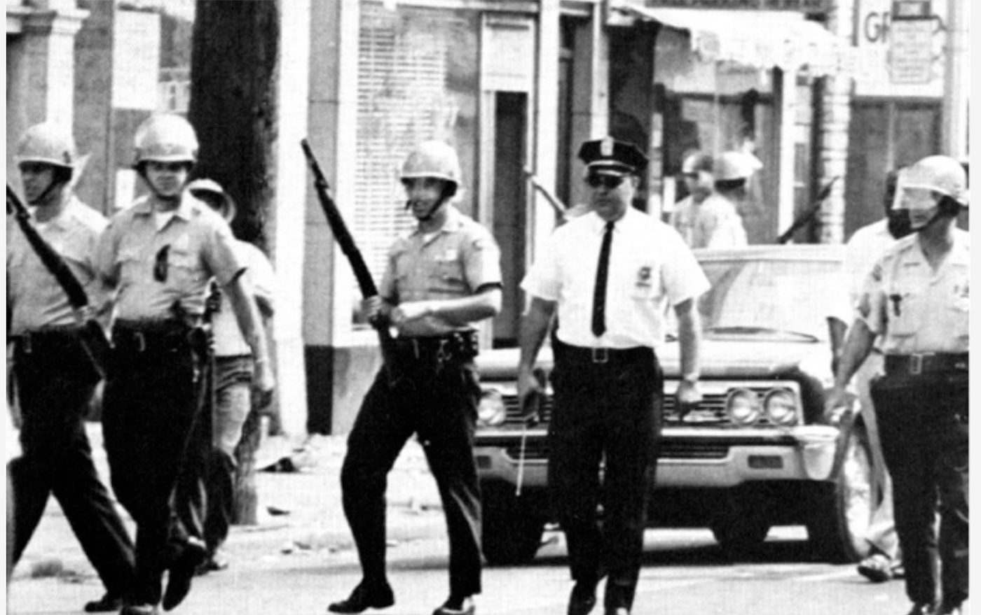 Guardsmen and police patrol a riot-torn street